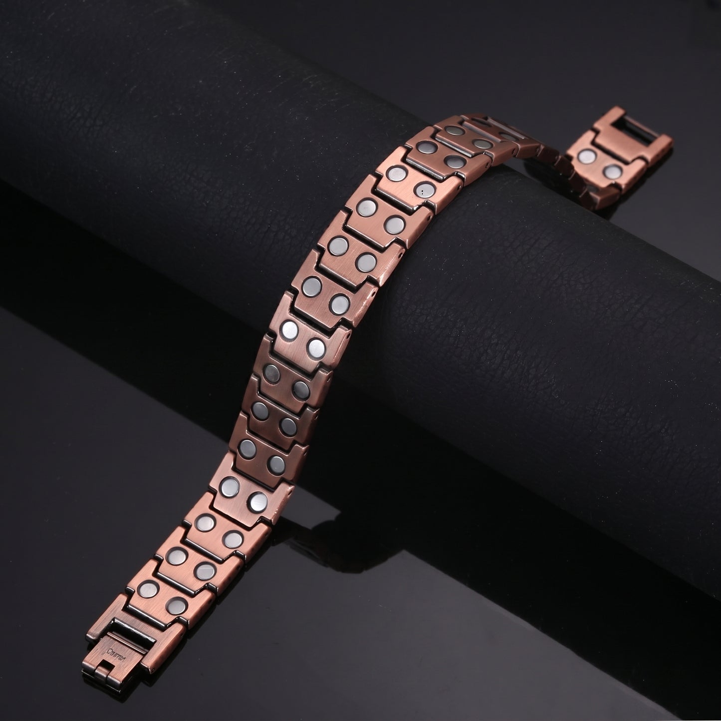 copper Celtic Cross bracelet showing its magnetic design and open box clasps on a dark background.