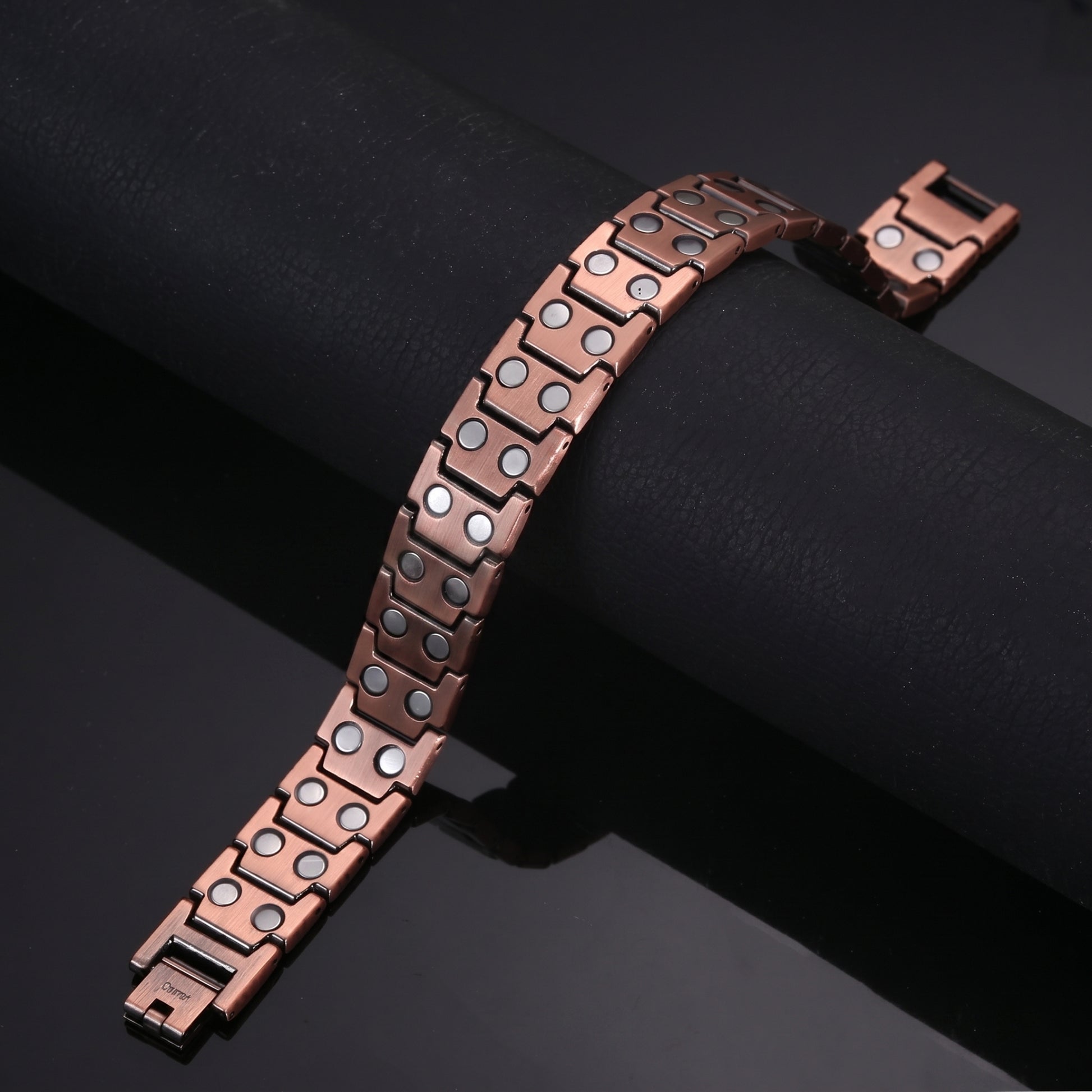 copper Celtic Cross bracelet showing its magnetic design and open box clasps on a dark background.