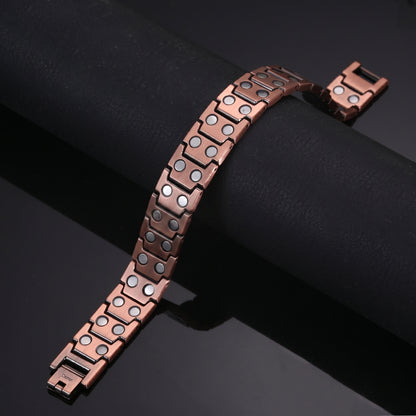 copper Celtic Cross bracelet showing its magnetic design and open box clasps on a dark background.